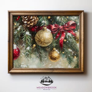 May include: A framed Christmas-themed painting. The artwork depicts a festive arrangement of evergreen branches, red ornaments, a gold ornament, a red bow, and a pinecone, all dusted with snow. The painting is in a wooden frame.