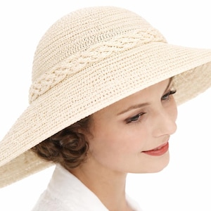 Peut inclure: Un chapeau de soleil crème avec un large bord et une bande tressée. Le chapeau est fait de matériau tissé et a une couronne arrondie. Le chapeau est conçu pour fournir de l'ombre du soleil.