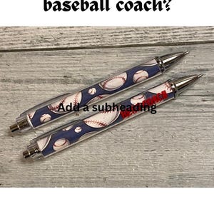 May include: Two retractable ballpoint pens featuring a dark blue background with a repeating white baseball pattern and red stitching. The text "Need a gift for the best baseball coach?" appears at the top, and "Add a subheading" is in the center.