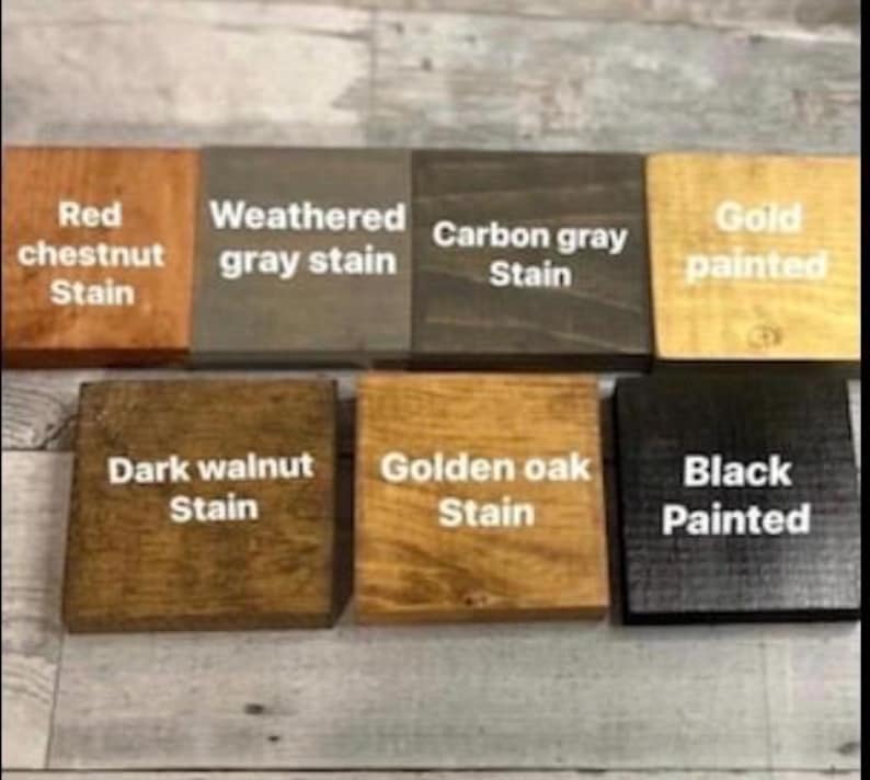 May include: Seven square wooden blocks arranged in two rows, each featuring a distinct finish and white text labels: Red chestnut Stain, Weathered gray stain, Carbon gray Stain, Gold painted, Dark walnut Stain, Golden oak Stain, and Black Painted.