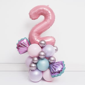 May include: A pink number two balloon with a cluster of pastel pink, purple, and blue balloons, including two iridescent seashell balloons.