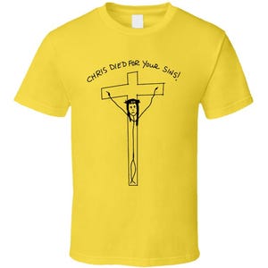 May include: Yellow t-shirt with a black graphic of a person on a cross, with the text "CHRIS DIED FOR YOUR SINS!" in a handwritten style. The shirt is a crew neck style.