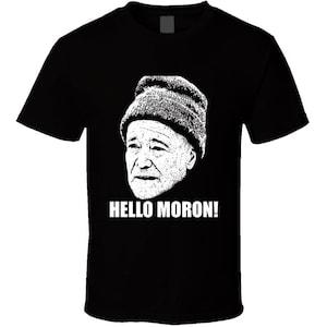 May include: Black t-shirt with a white image of a man wearing a hat and the text "HELLO MORON!"