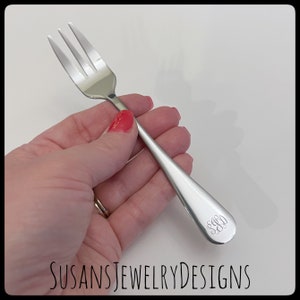 May include: A silver fork with a monogrammed handle. The monogram is "S.G.D."