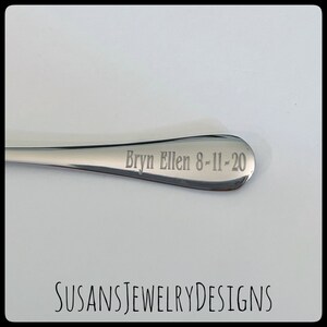 Puede incluir: Una cuchara de acero inoxidable pulido con la inscripci&oacute;n grabada "Bryn Ellen 8-11-20" en el cuenco. La cuchara se muestra sobre un fondo blanco. El texto "SUSANSJEWELRYDESIGNS" est&aacute; en la parte inferior de la imagen.