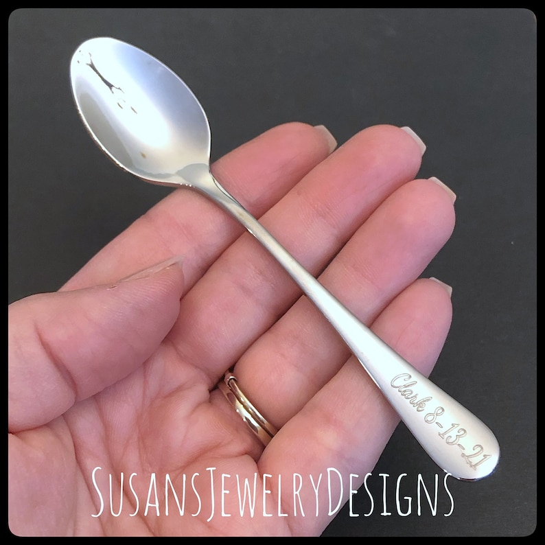 May include: A silver teaspoon with a personalized inscription that reads "Clark 8-18-21".