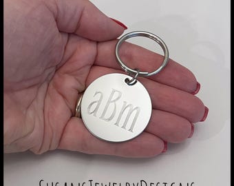 May include: Silver keychain with a round tag engraved with the monogram "aBm".