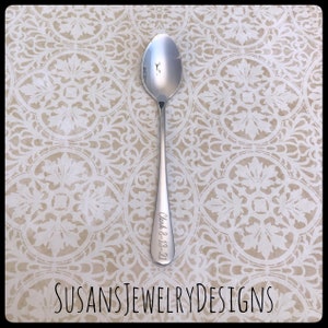 May include: A silver spoon with the date "July 8, 18-21" engraved on the handle.
