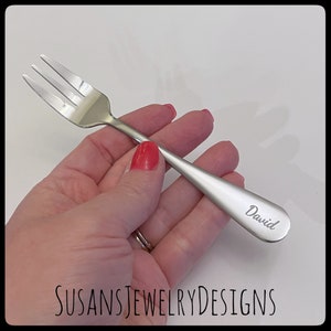May include: A silver fork with a personalized inscription that reads "David".