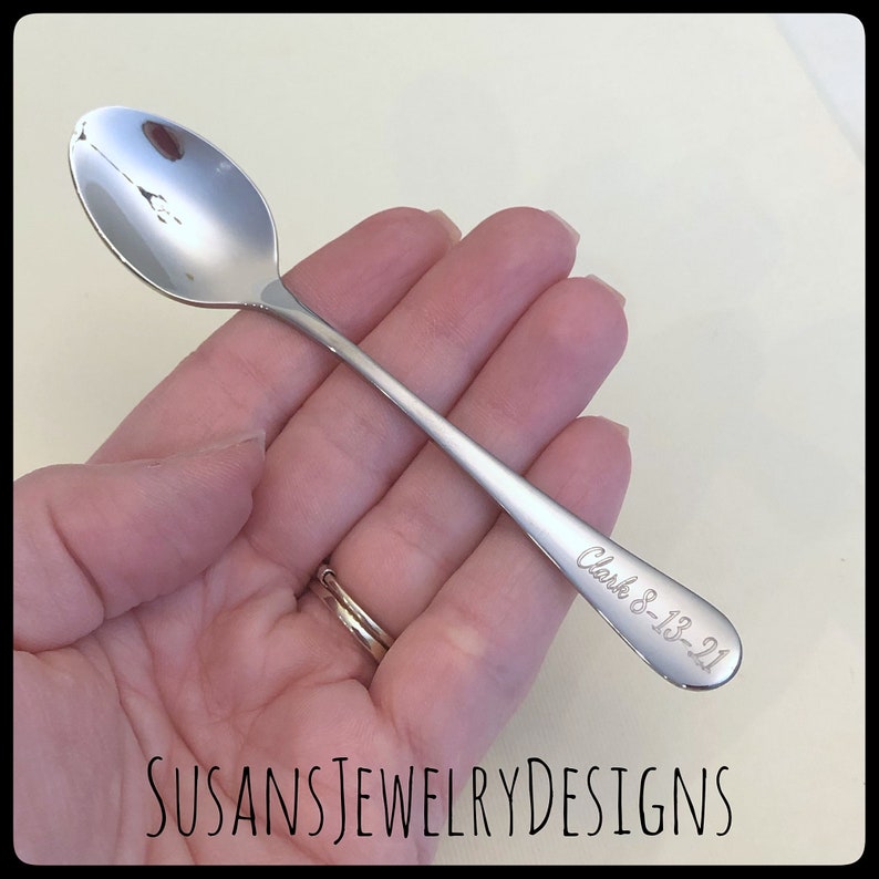 May include: A silver teaspoon with a personalized inscription that reads "Clark 8-13-21".