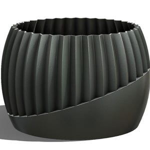 May include: A dark gray, decorative planter with a unique design. The upper portion features vertical, ridged detailing, while the lower section has a smooth, angled surface. The planter is designed for indoor or outdoor use.