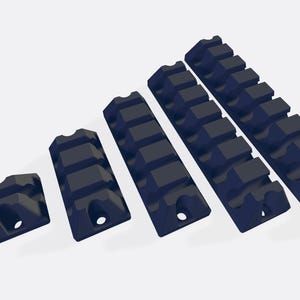 May include: A set of six black plastic cable organizers in various sizes. The organizers have a series of ridges to hold cables in place.