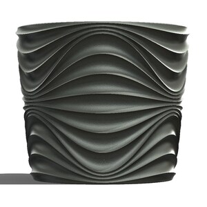 May include: A dark grey, cylindrical planter with a wavy, textured design. The planter has a wide opening and a solid base. The design is repeated on the top and bottom halves of the planter.