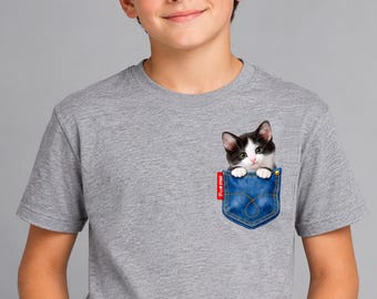 May include: A heather gray short-sleeved t-shirt featuring a printed graphic of a blue denim pocket with a black and white kitten peeking out. The pocket graphic includes a small red tag with the white text "PIC★STAR" on the side.