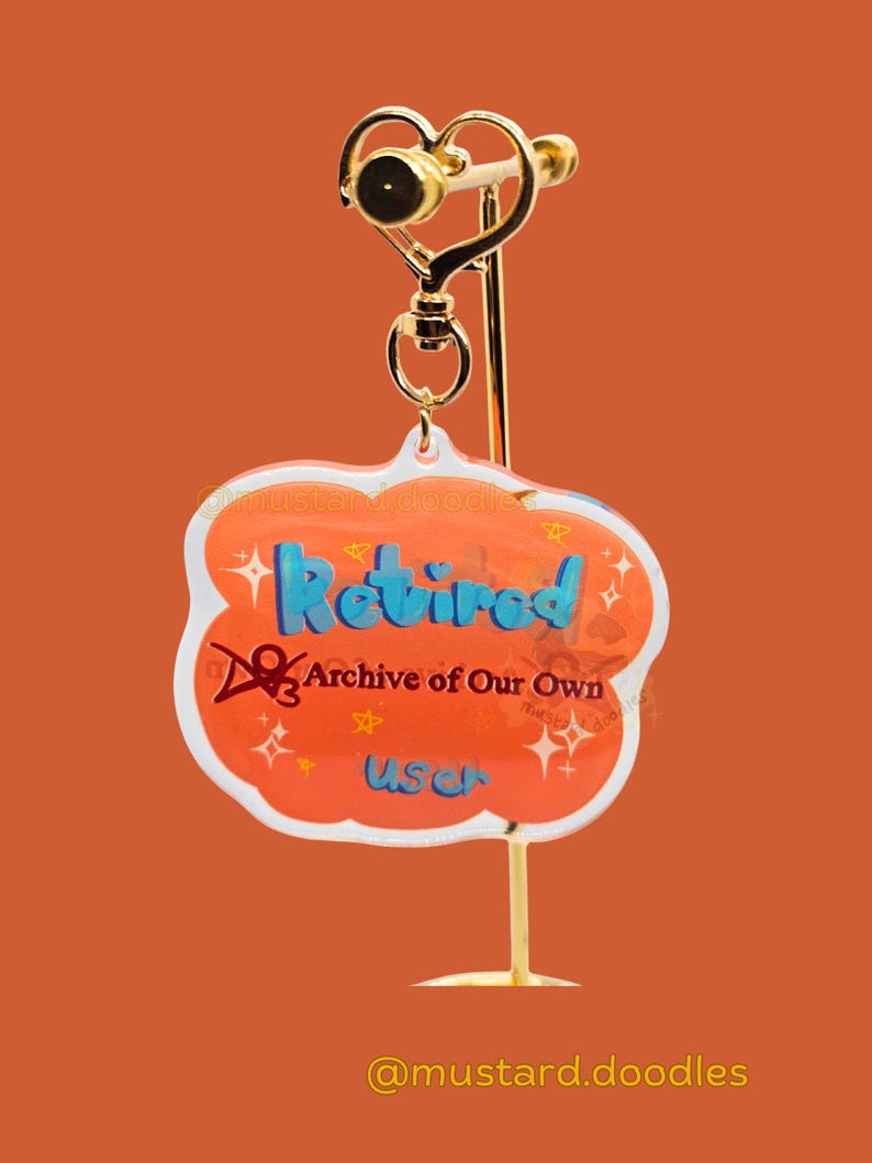 May include: A gold-colored earring display stand with a heart-shaped top. The earring features a cloud-shaped charm with the word "Retired" in blue, and the text "Archive of Our Own User". The charm is orange with white accents.