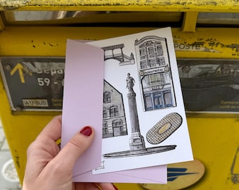 May include: A postcard with a hand-drawn illustration of a building with the text "SACHMUTTERIE" above the door. The postcard is being placed in a yellow mailbox.
