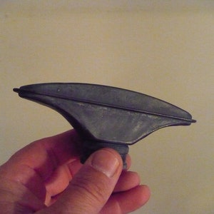 May include: A gray metal bottle nozzle with a curved top and a threaded base.