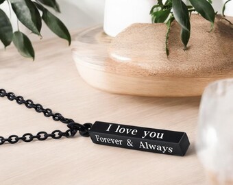 May include: A black necklace with a black bar pendant that reads "I love you Forever & Always".