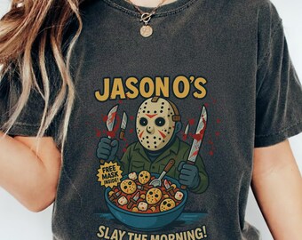 Może przedstawiać: Ciemnoszara koszulka z grafiką Jasona Voorheesa z Piątku 13. Projekt zawiera tekst "JASON O'S" i "SLAY THE MORNING!" z miską płatków śniadaniowych i nożami.