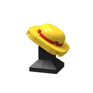 Puede incluir: Un sombrero de paja amarillo y rojo con una base negra. El sombrero está hecho de plástico y tiene un diseño simple.