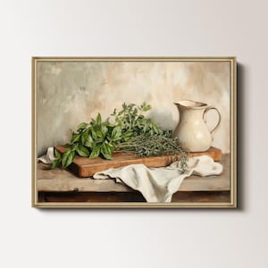Peut inclure: Peinture de nature morte encadrée représentant une planche à découper en bois avec des herbes vertes fraîches, une cruche blanche et un tissu blanc. Le fond a des tons neutres, et la peinture est dans un cadre doré.