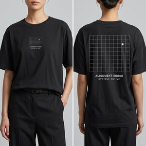 Può includere: T-shirt nero con grafica a griglia bianca e testo "ALIGNMENT ERROR SYSTEM: ACTIVE" sul davanti e sul retro. La maglietta ha girocollo e maniche corte. La modella indossa pantaloni neri.