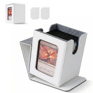 May include: A white deck box with a textured exterior and a gray interior lining. The front features a clear window displaying an Emberstorm Phoenix trading card. The base is embossed with the text DeckDwell. Two blank white inserts are included.
