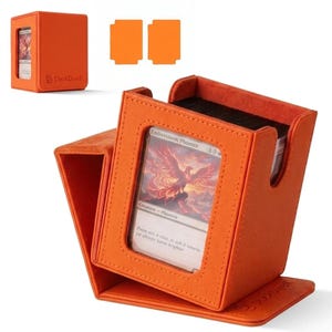 May include: An orange textured deck box for trading cards with a rectangular display window on the front. The box holds a card titled Emberstorm Phoenix. A smaller, closed version of the same orange deck box is visible in the upper left corner.