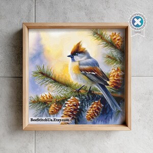 May include: A square framed wall art piece featuring a detailed illustration of a small bird with a crest perched on a pine branch with brown cones. The background shows a soft yellow and blue sky. The text BeeStitchUa.Etsy.com is at the bottom.