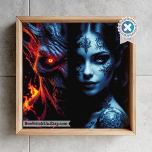 May include: A square framed wall art piece featuring a split-face design. The left side shows a textured, dark creature with glowing red eyes and orange flames. The right side depicts a person with blue skin, intricate black lace patterns, and a floral tattoo.