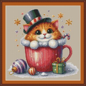 May include: A cross-stitch design featuring a ginger cat wearing a top hat and scarf, peeking out of a red mug. The scene includes a candy cane, ornaments, and a wrapped gift, all set against a neutral background. The image has a festive, holiday theme.