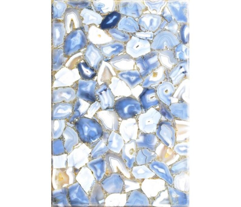 May include: Rectangular surface composed of irregularly shaped blue, white, and tan agate stones. The stones are tightly fitted together, creating a mosaic-like pattern. The edges of the stones are outlined with a gold-colored material.