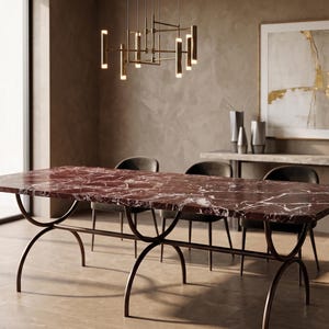 Pode incluir: Uma mesa de jantar retangular com tampo de mármore vermelho e pernas de metal escuro. A mesa é rodeada por quatro cadeiras pretas. Uma moderna luminária pendurada está pendurada acima da mesa. Uma pintura e vasos decorativos estão no fundo.