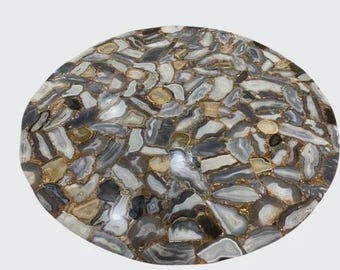 May include: A circular tabletop featuring a mosaic of polished agate slices in shades of gray, white, and tan. The individual stone pieces are arranged in a dense, interlocking pattern with gold-toned metallic grout filling the gaps between them.