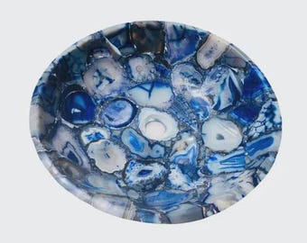 Pode incluir: Uma tigela redonda e decorativa com um design de mosaico. A tigela é feita de pedra natural polida em tons de azul e branco. As peças de pedra são dispostas em um padrão, criando uma superfície única e atraente.