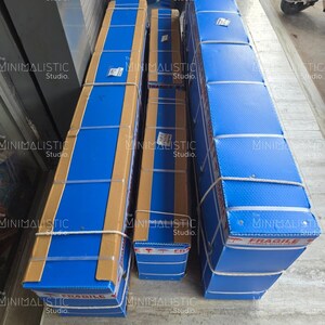 May include: Three rectangular packages wrapped in blue and brown cardboard, secured with white rope. The packages are labeled with the text "FRAGILE" and "The MINIMALISTIC Studio."