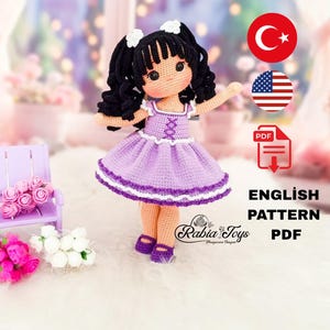 K&ouml;nnte beinhalten: H&auml;kelpuppenmuster in Englisch und PDF-Format. Die Puppe tr&auml;gt ein lila Kleid mit wei&szlig;em Besatz und hat schwarze Haare mit wei&szlig;en Schleifen. Das Muster ist in Englisch und T&uuml;rkisch verf&uuml;gbar.