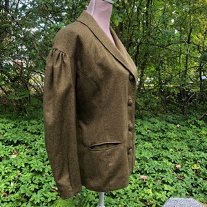 May include: A green wool blazer with a single-breasted closure and a patch pocket on the left side. The blazer has a slightly fitted silhouette and a collar with a pointed lapel.