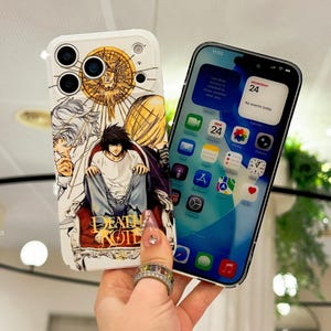 May include: A white smartphone case featuring a Death Note graphic with the character L sitting on a red chair, surrounded by gold and white illustrations. Next to it is a smartphone displaying a digital interface with app icons and a calendar.