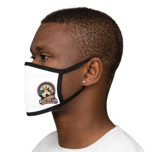 May include: White face mask with black trim featuring a soccer ball design, a crown, and the text "WORLD CUP 2026 CANADA USA MEXICO". The mask is worn by a person.