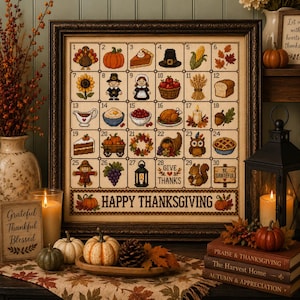 Puede incluir: Un calendario de punto de cruz enmarcado para noviembre con treinta cuadrados numerados que muestran iconos de Acción de Gracias como pavos, calabazas y pasteles. El borde inferior muestra el texto HAPPY THANKSGIVING en un marco de madera.