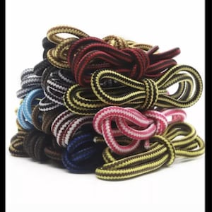 以下が含まれることがあります： 黒、白、赤、黄、青、茶色など、さまざまな色のストライプの靴ひもが積み重ねられています。