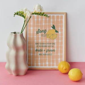 May include: A printable wedding song request card with a lemon illustration and a gingham background. The text reads "Song Request, Want to hear a certain song at the wedding? Help the bride + groom make their playlist."