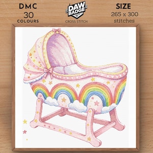 Puede incluir: Una cuna rosa y blanca para bebé con un diseño de arcoíris y estrellas. La cuna está sobre una base de balanceo. La imagen es para un patrón de punto de cruz.