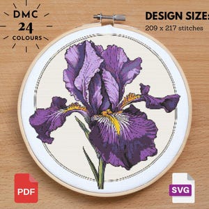 May include: Cross-stitch embroidery of a purple iris flower in a wooden hoop. The design size is 209 x 217 stitches. The text reads "DMC 24 COLOURS". Includes PDF and SVG file icons.