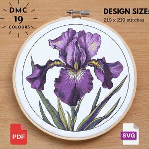 May include: Cross-stitch embroidery of a purple iris flower in a wooden hoop. The design size is 219 x 219 stitches and uses 19 colors. Includes PDF and SVG file icons. The text "DMC 19 COLOURS" is at the top.