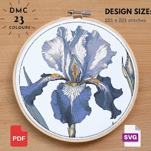 Puede incluir: Un patrón de punto de cruz de una flor de iris azul y blanco con 23 colores DMC. El tamaño del diseño es de 221 x 221 puntos.