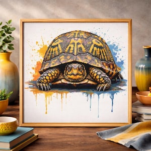 May include: A framed cross-stitch art piece featuring a detailed turtle with a patterned shell in shades of brown and yellow. The artwork is set against a white background with orange and blue watercolor splashes, and is displayed in a wooden frame.