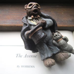 May include: A set of three ceramic mugs with a speckled, cream-colored glaze. Each mug features a different hand-painted floral design in shades of blue, green, and yellow. The mugs have a simple, rounded shape and a comfortable handle.