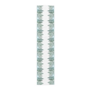 Puede incluir: Un camino de mesa rectangular con un patr&oacute;n repetido de &aacute;rboles de hoja perenne estilizados en tonos verdes y blancos. Los &aacute;rboles est&aacute;n dispuestos en filas verticales sobre un fondo azul claro y blanco, creando un tema invernal.